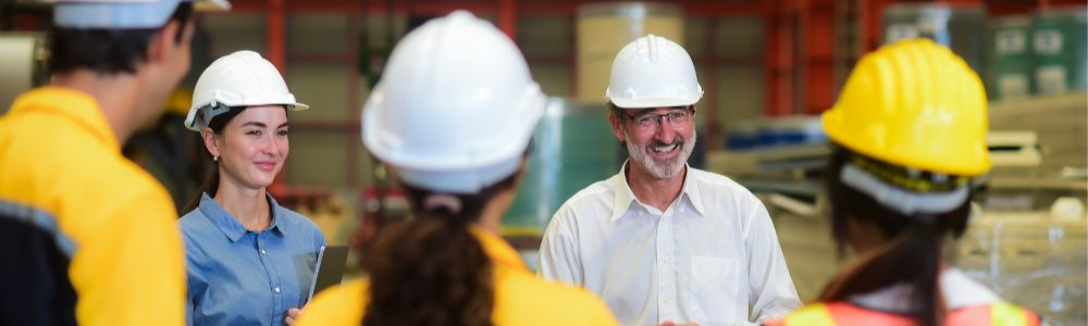 Arbejder med hjelm, der arbejder på en industrifabrik eller i et lager
