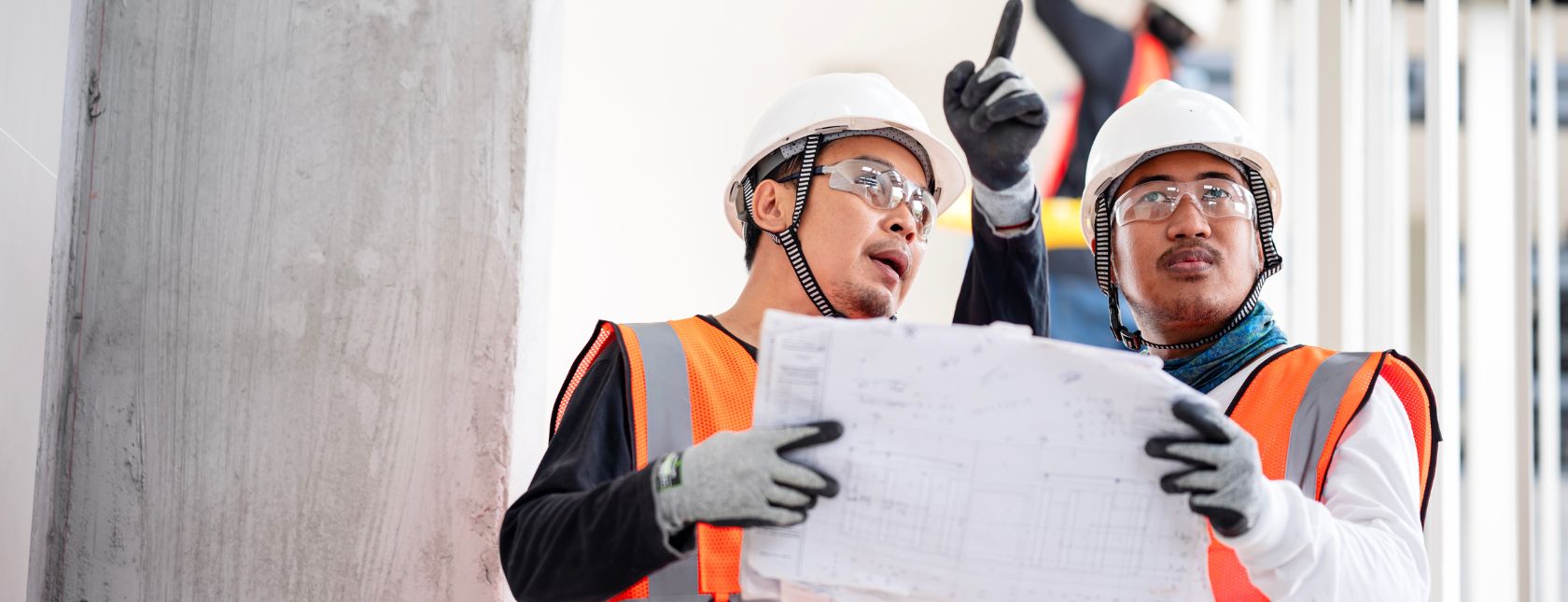 Bygningsingeniører diskuterer et blueprint eller detaljer om en projektopgave